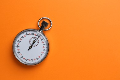 Vintage timer on orange background, top view. Space for text