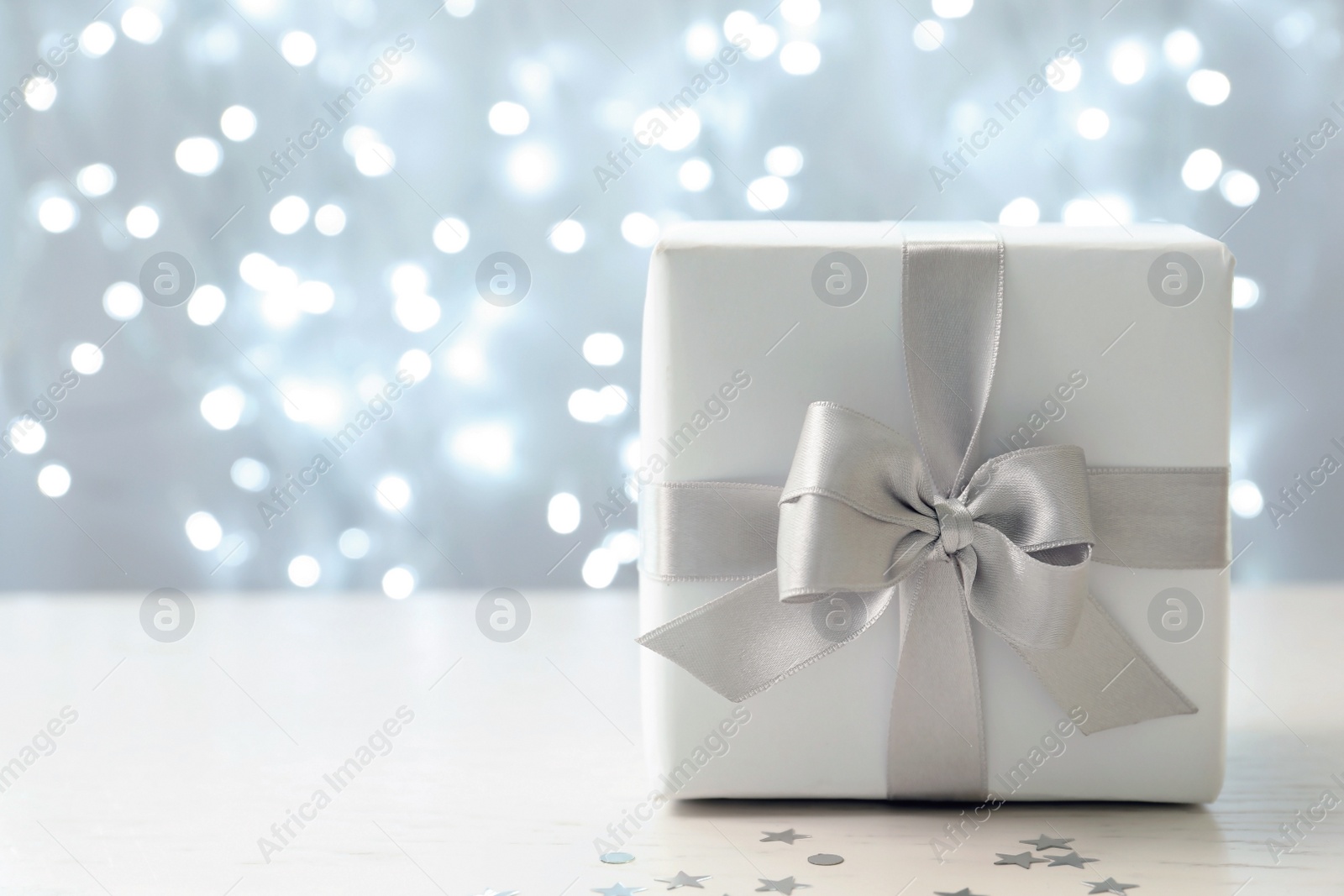 Photo of Christmas gift on table against blurred background