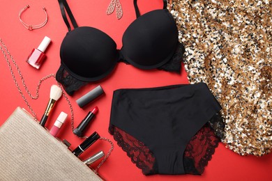 Photo of Flat lay composition with black women's underwear and cosmetic products on red background