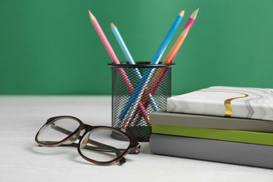Photo of Composition with glasses and notebooks for Teacher's day on white table