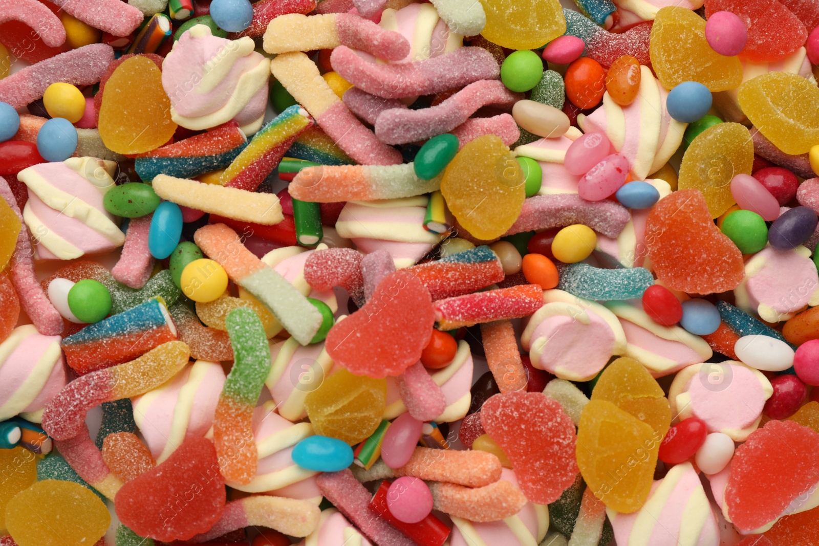 Photo of Different tasty candies as background, top view