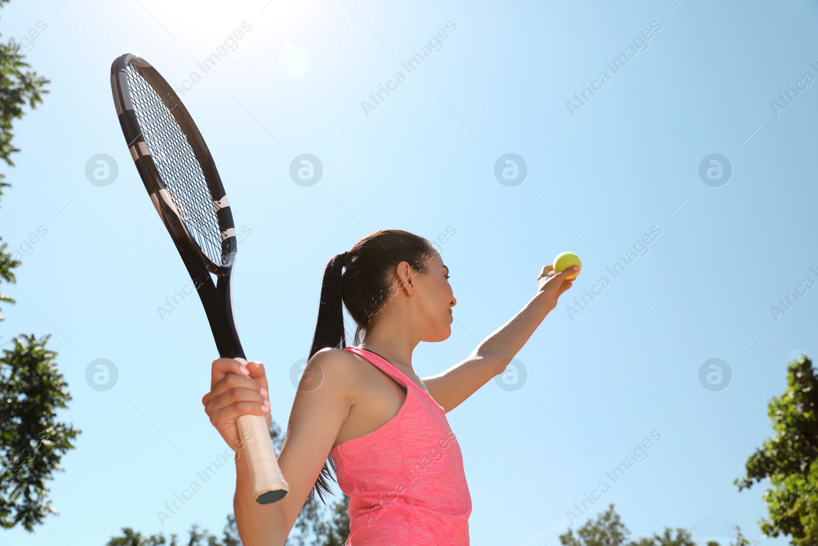 Photo of Woman playing tennis outdoors, low angle view