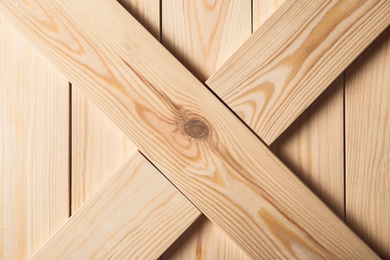 Photo of Wooden crate with crossed planks as background, closeup