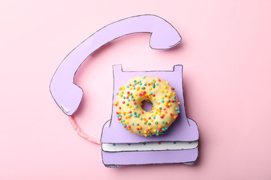Photo of Vintage phone made with donut on pink background, top view