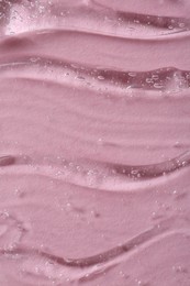 Clear cosmetic serum on pink background, macro view