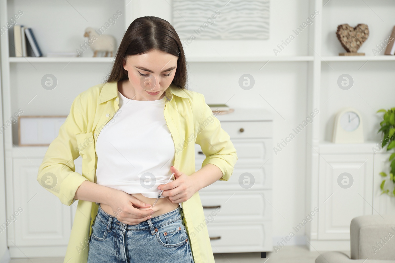 Photo of Diabetes. Woman making insulin injection into her belly at home, space for text