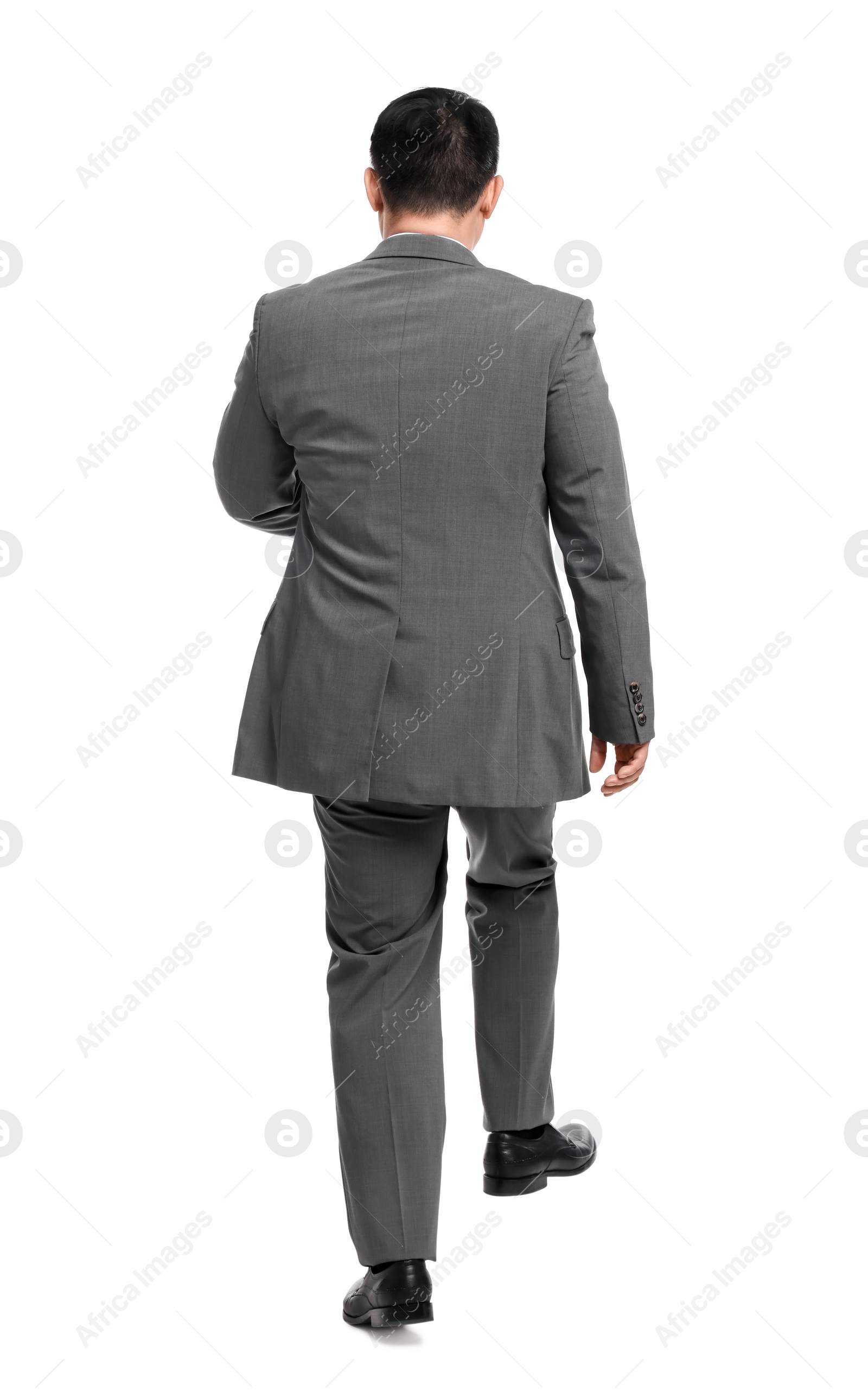 Photo of Businessman in suit walking on white background, back view