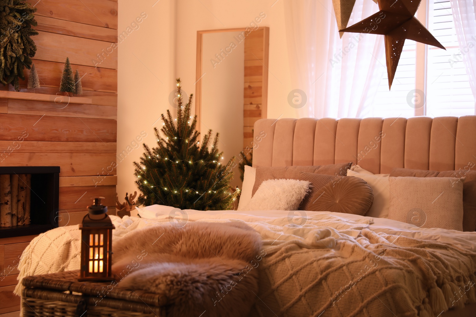 Photo of Beautiful decorated Christmas tree with fairy lights in bedroom interior