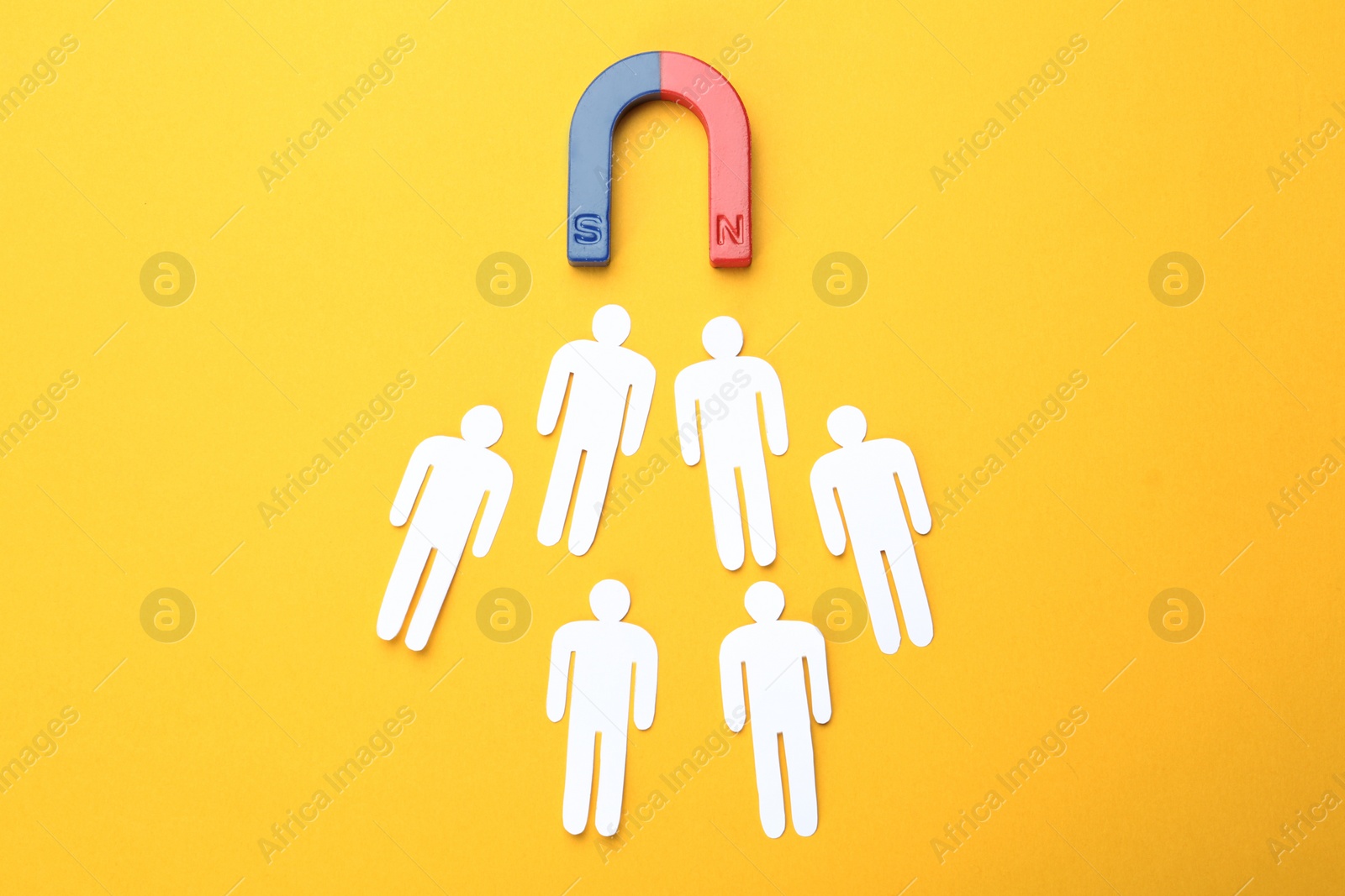 Photo of Magnet attracting people traffic on color background, top view. Marketing concept