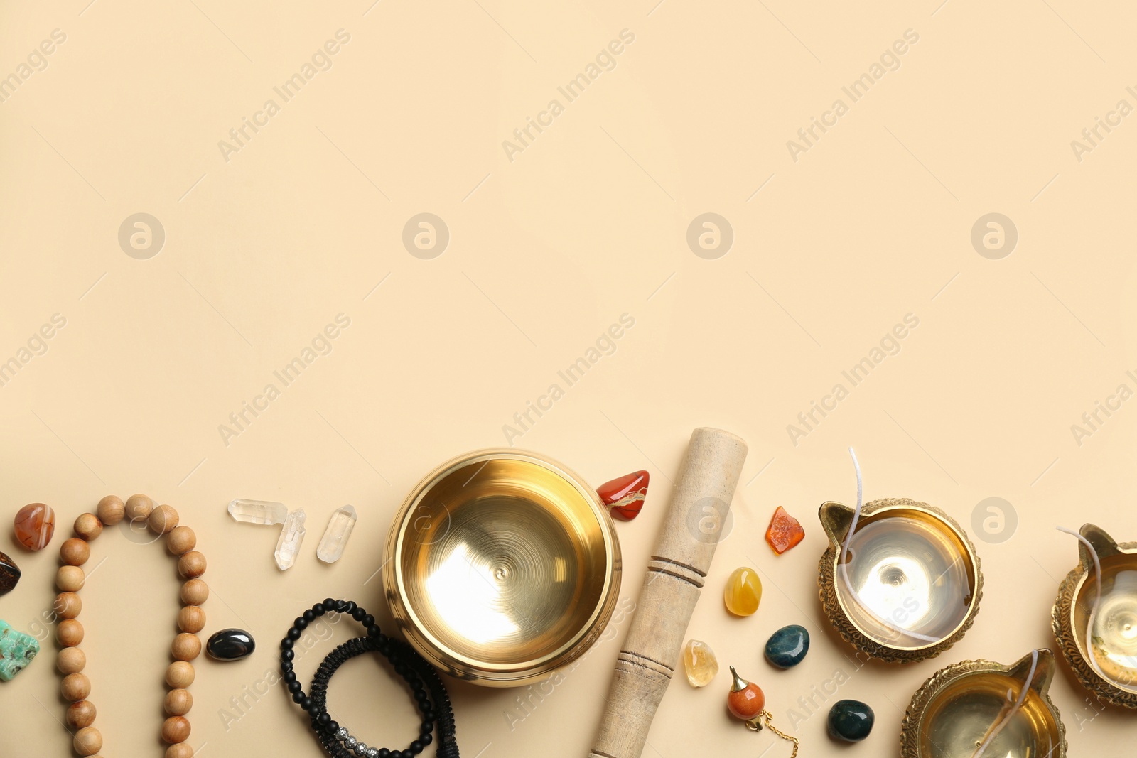 Photo of Flat lay composition with golden singing bowl on beige background, space for text. Sound healing