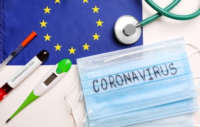 Photo of Flat lay composition with European Union flag and medical items on white background. Coronavirus outbreak