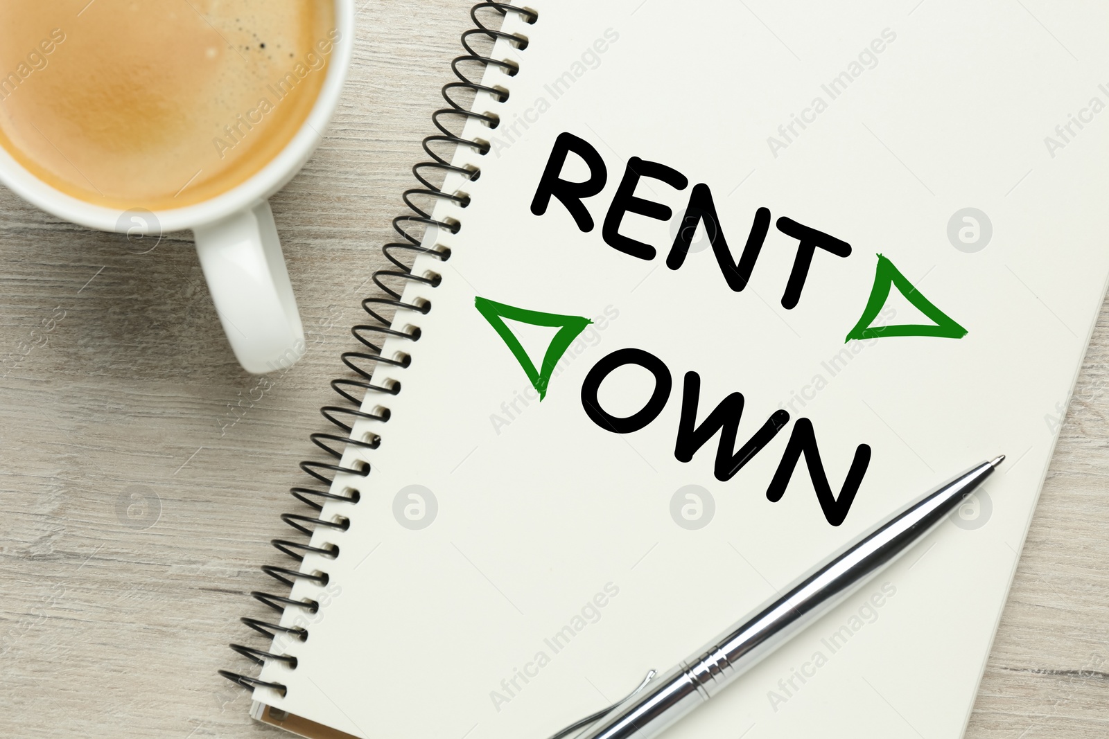 Image of Buy or rent - choice concept. Notebook, pen and cup of coffee on wooden background, flat lay