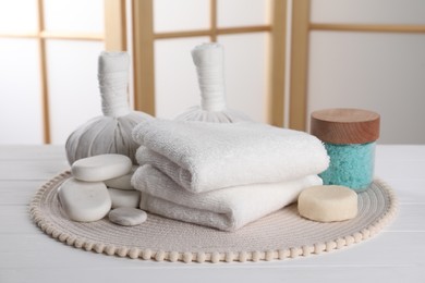Spa composition with care products on white wooden table in room