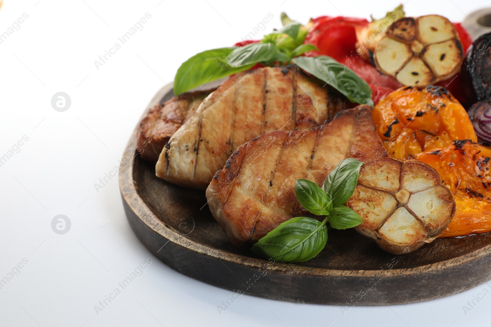 Photo of Board with tasty grilled vegetables, meat and basil isolated on white