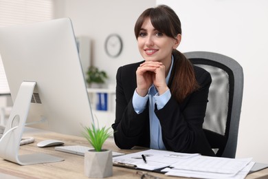 Photo of Portrait of smiling secretary at table in office