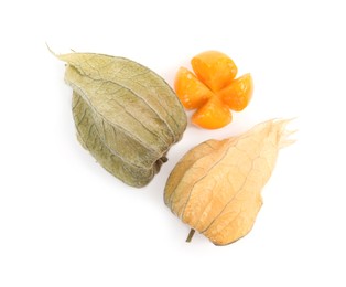 Cut and whole ripe physalis fruits with dry husk on white background, top view
