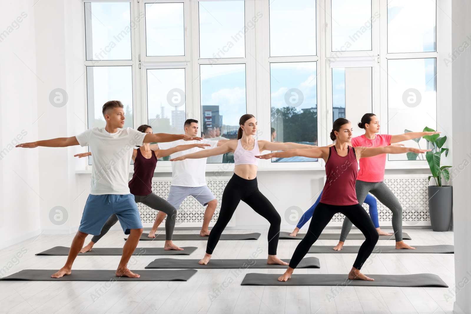 Photo of Group of people practicing yoga on mats indoors