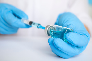 Photo of Doctor filling syringe with medication, closeup. Vaccination and immunization