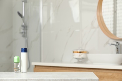 Photo of Different deodorants on table in bathroom, space for text