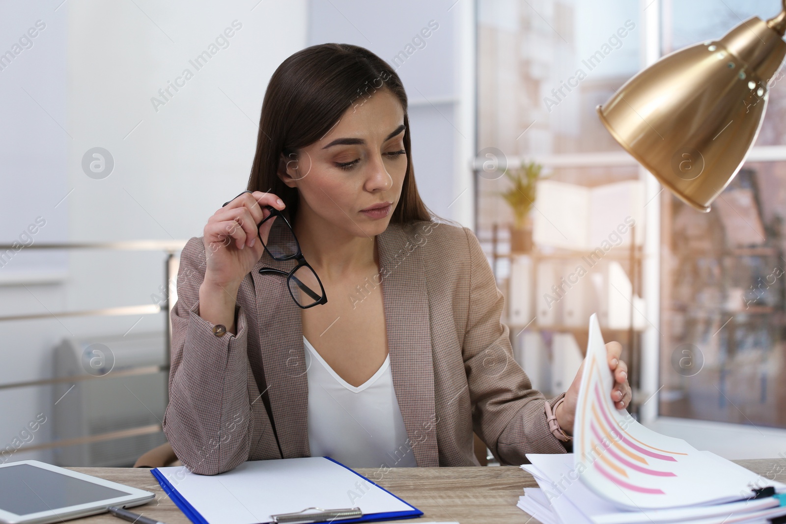 Photo of Businesswoman working with documents at table in office