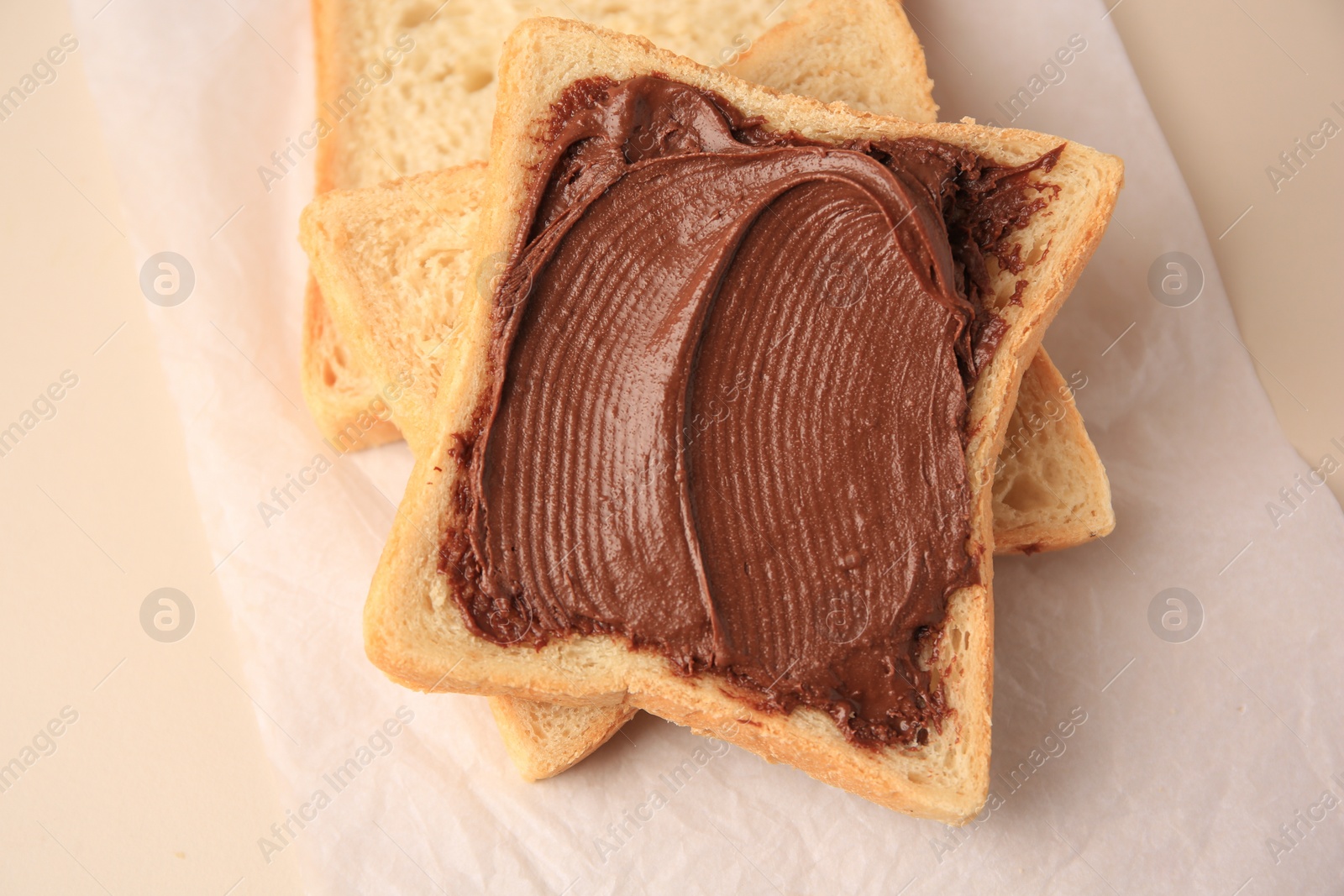 Photo of Tasty toast with chocolate paste on light background, above view