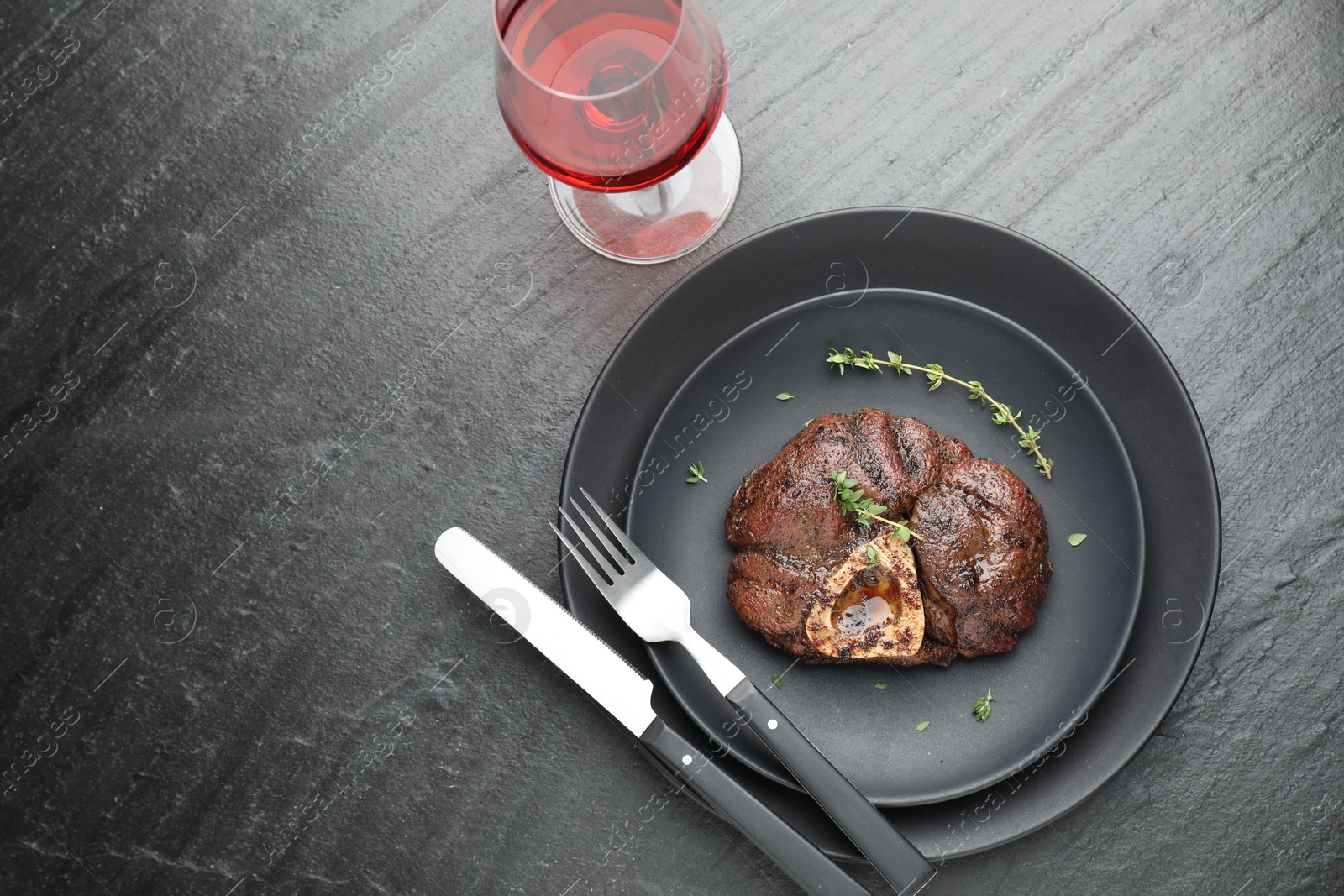 Photo of Tasty grilled beef meat served on black table, flat lay. Space for text