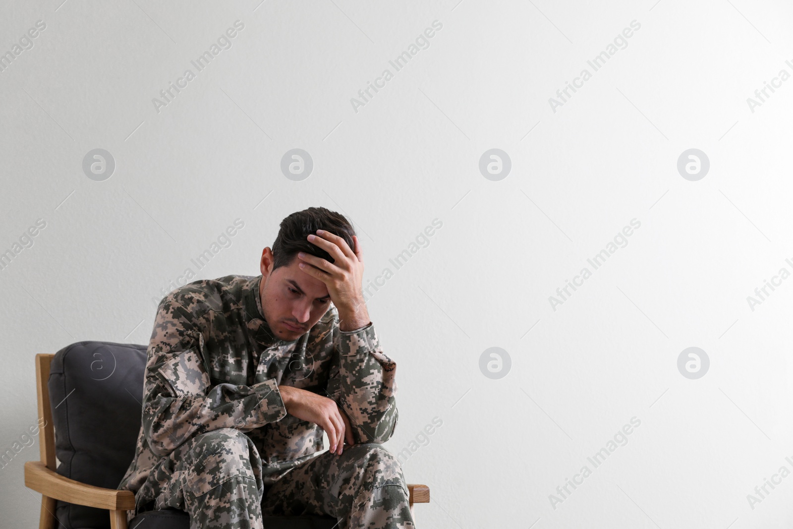 Photo of Stressed military officer sitting in armchair on white background. Space for text