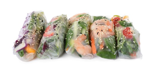 Photo of Many different rolls wrapped in rice paper on white background