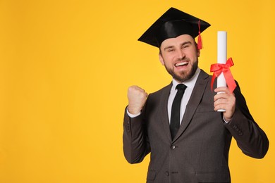 Emotional student with graduation hat and diploma on yellow background. Space for text