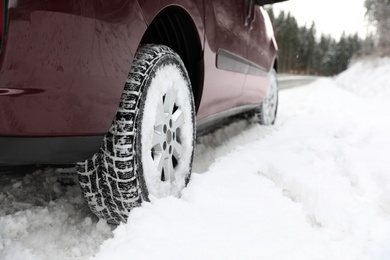 Photo of Closeup view of car in snow near road. Space for text