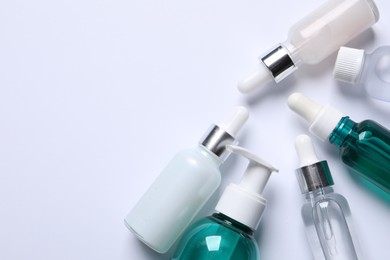 Face serums and other skin care products on white background, flat lay. Space for text