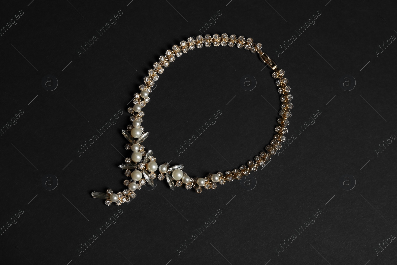 Photo of Stylish necklace with gemstones on black background, top view. Luxury jewelry