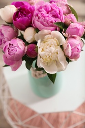 Photo of Vase with bouquet of beautiful peonies on table, above view