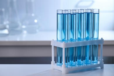 Photo of Test tubes with reagents on table in laboratory, space for text
