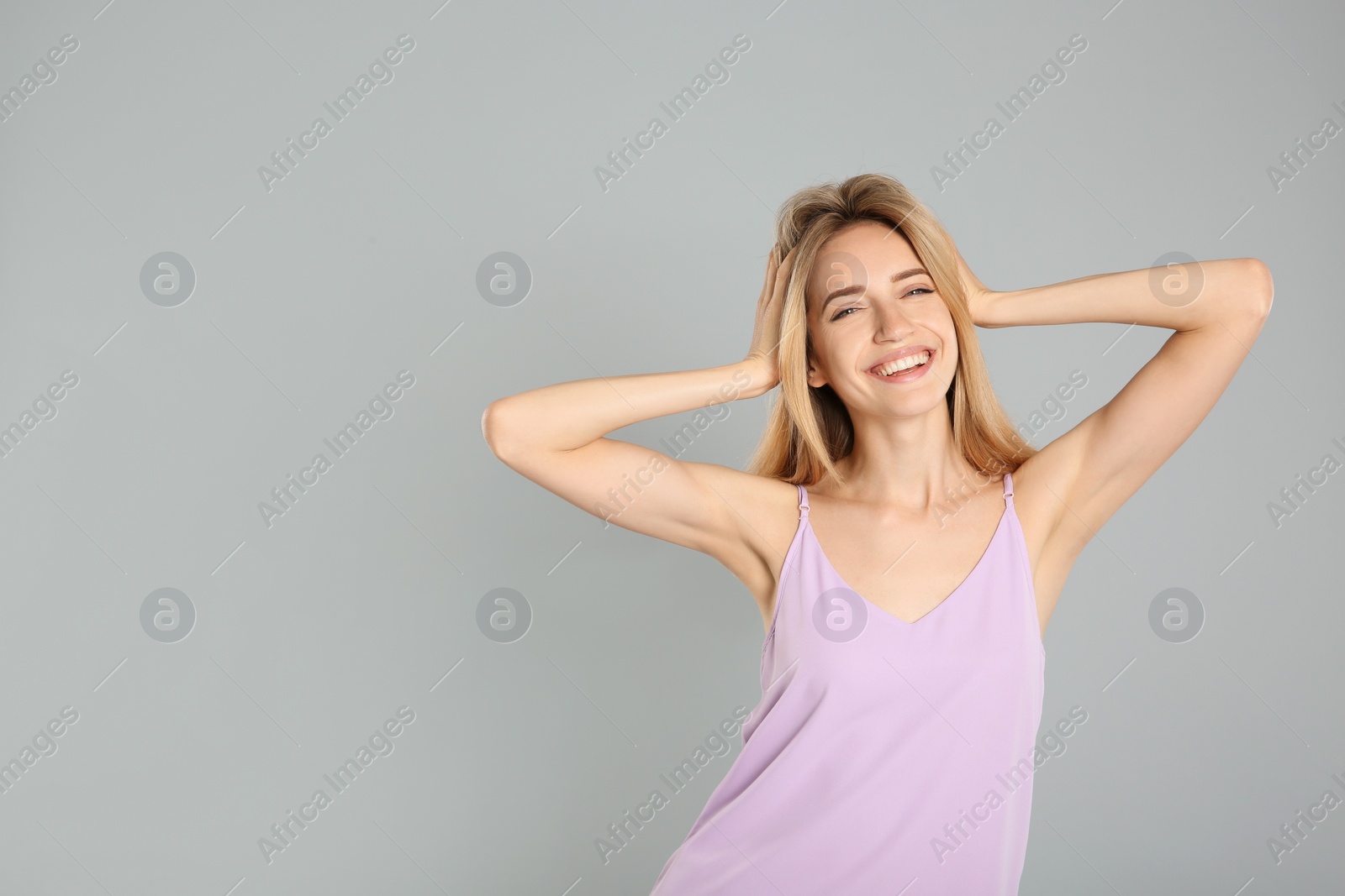 Photo of Portrait of beautiful young woman with blonde hair on grey background