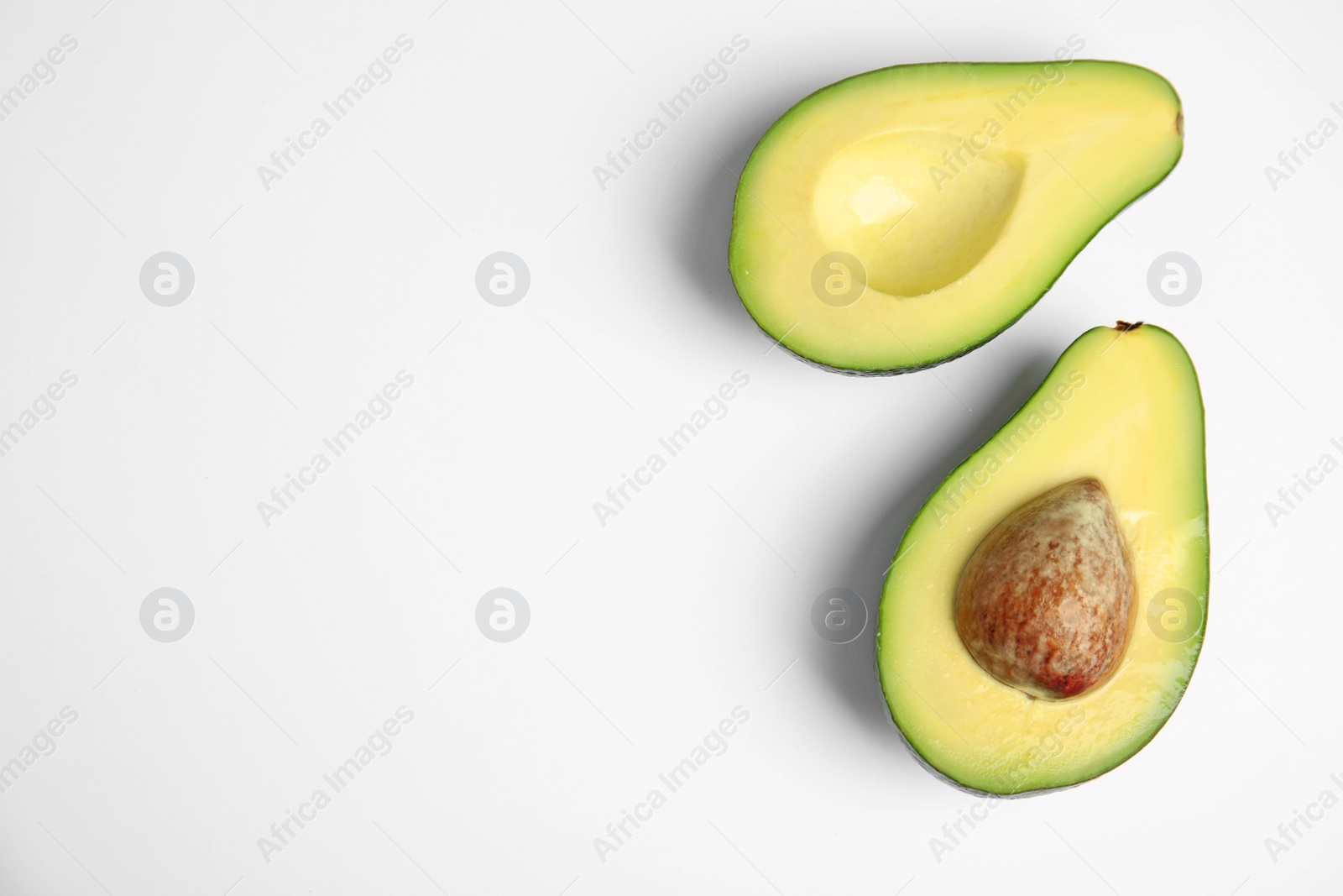 Photo of Cut fresh ripe avocado on white background, top view