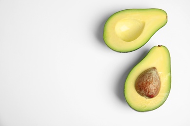 Cut fresh ripe avocado on white background, top view