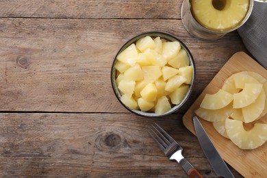 Photo of Flat lay composition with canned pineapple on wooden table. Space for text