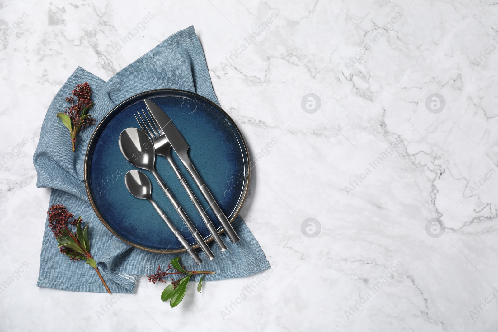 Photo of Stylish setting with elegant cutlery on white marble table, top view. Space for text