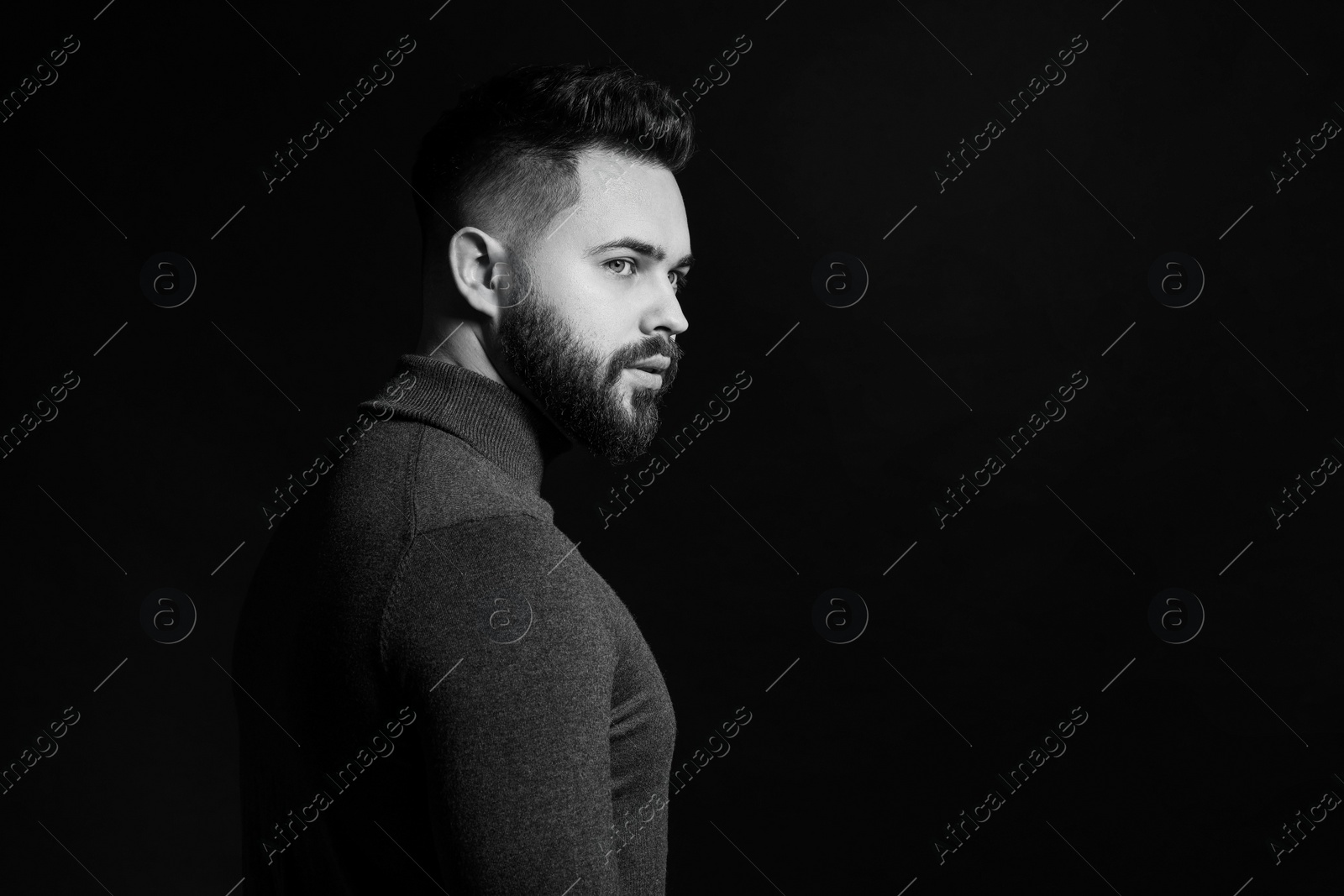 Photo of Portrait of handsome bearded man on dark background, space for text. Black and white effect