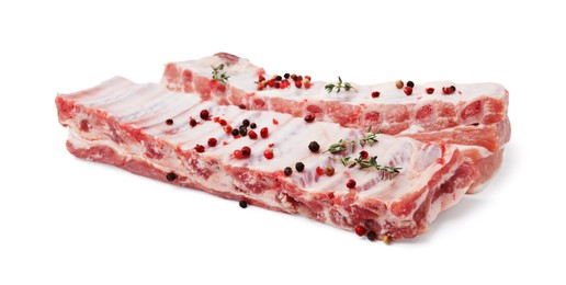 Photo of Raw pork ribs with thyme and peppercorns isolated on white