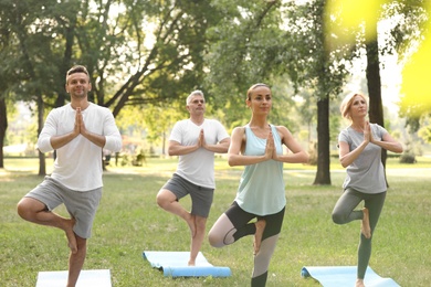 Photo of People practicing yoga in park at morning