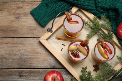 Photo of Hot mulled cider, ingredients and fir branches on wooden table, flat lay. Space for text