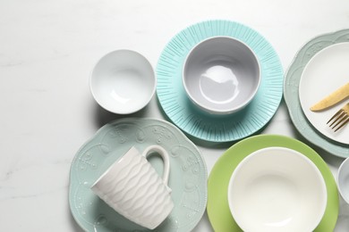 Photo of Beautiful ceramic dishware, cup and cutlery on white marble table, flat lay