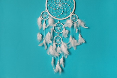 Photo of Beautiful dream catcher hanging on light blue background