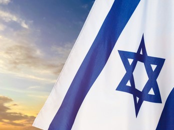 Image of National flag of Israel against blue sky with clouds