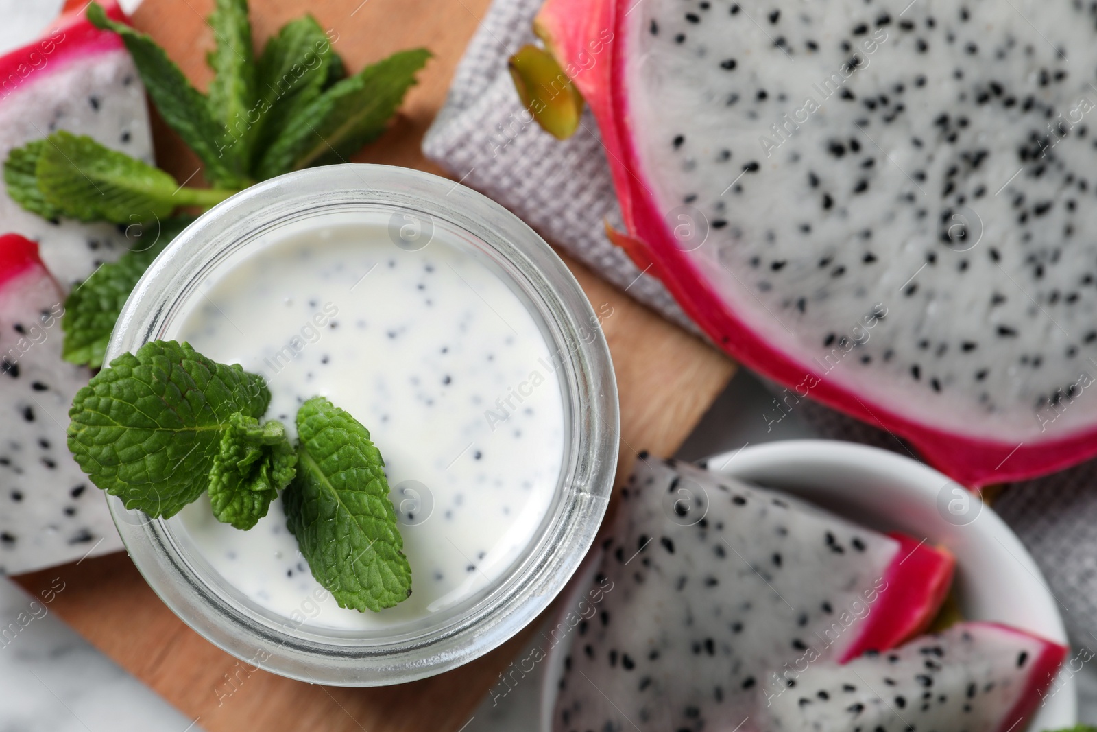 Photo of Tasty pitahaya smoothie, fruits and fresh mint on white marble table, flat lay