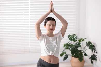 Photo of Girl practicing crescent asana in yoga studio. High lunge pose
