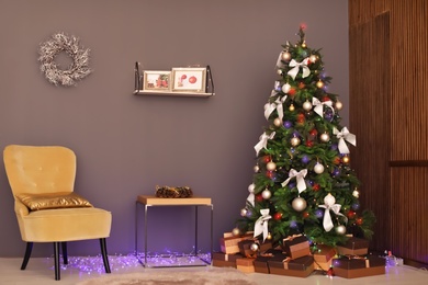 Photo of Room interior with beautiful Christmas tree and gifts