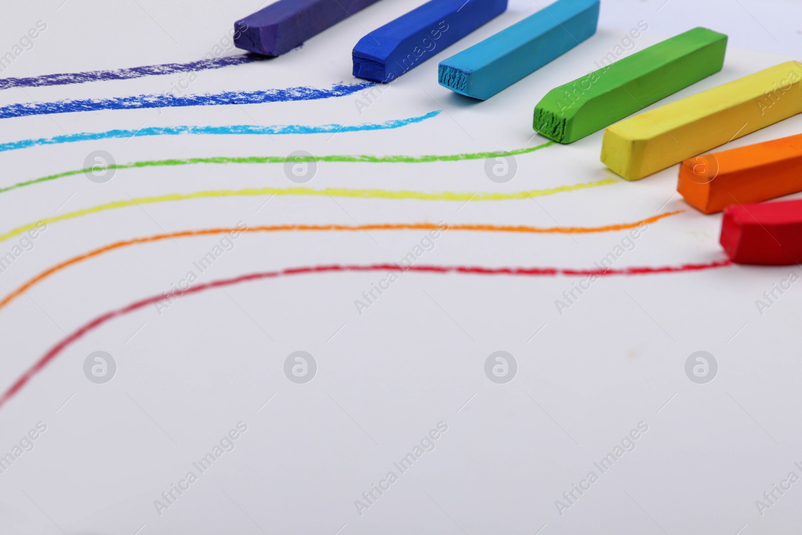 Photo of Colorful pastel chalks and lines on white background. Drawing materials